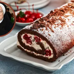 Siostra Anastazja z uśmiechem prezentuje swój słynny tort czekoladowy z wiśniami, inspirowany nalewką z wiśni siostry Anastazji.