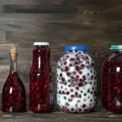 Słoje i butelki z wiśniami, gotowe na nalewkę z wiśni - przepis babci.