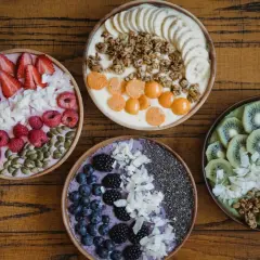 Cztery kolorowe smoothie bowls z owocami, granolą i nasionami. Idealne na śniadanie, gdy chcesz wiedzieć, jakie płatki owsiane kcal wybrać.
