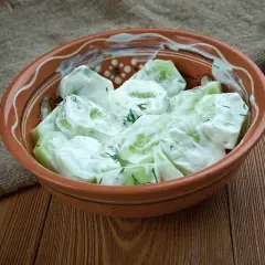 Mizeria z jogurtem, świeża i lekka, w glinianej misce. Idealna na letni obiad.