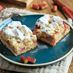 Pyszne ciasto z rabarbarem posypane cukrem pudrem. Idealne na wiosenne popołudnie, gdy masz ochotę na domowy przepis na ciasto z rabarbarem.