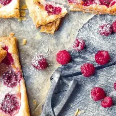 Pyszne ciasto francuskie z malinami, posypane cukrem pudrem. Idealne na deser, gdy chcesz poczuć smak lata.