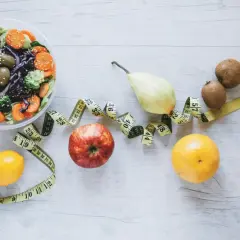 Sałatka, owoce i miarka krawiecka symbolizują zdrowy styl życia i dietę FODMAP.