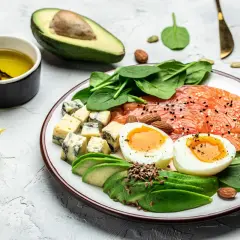 Pyszne, kolorowe danie idealne do diety keto menu: łosoś, jajka, awokado, ser pleśniowy, szpinak i migdały.