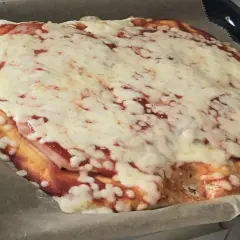 Domowa pizza z szybkim przepisem na ciasto, pokryta sosem pomidorowym i rozpływającym się serem. Idealna na szybki obiad.