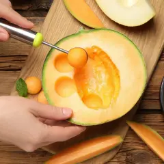 Ręka wydrąża kulki z melona, ukazując jego soczyste wnętrze. To dowód na bogactwo witamin i minerałów, czyli melon właściwości.