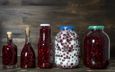 Słoje i butelki z wiśniami, gotowe na nalewkę z wiśni - przepis babci.