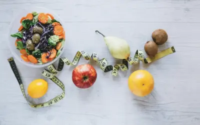 Sałatka, owoce i miarka krawiecka symbolizują zdrowy styl życia i dietę FODMAP.