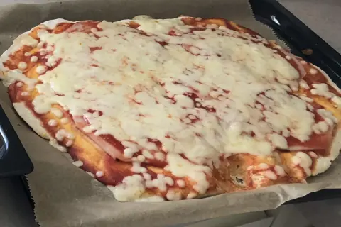 Domowa pizza z szybkim przepisem na ciasto, pokryta sosem pomidorowym i rozpływającym się serem. Idealna na szybki obiad.