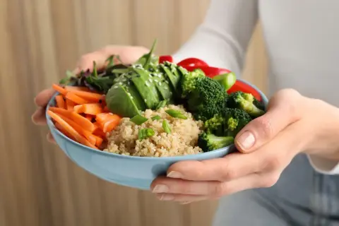 Miseczka pełna zdrowia: kasza quinoa jako źródło węglowodanów, awokado, marchewka, brokuły i papryka.