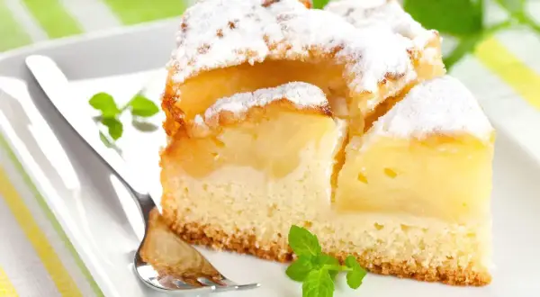 Pyszne, mega szybkie ciasto na oleju z jabłkami, posypane cukrem pudrem i udekorowane miętą. Idealne na deser.