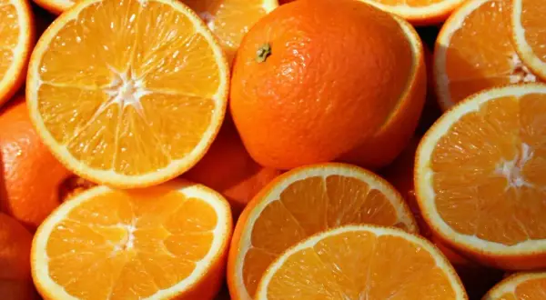 Soczyste pomarańcze, całe i przekrojone, kuszą swoim kolorem. Idealne na zdrową przekąskę, z niską zawartością pomarańcza kcal.
