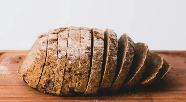 Pokrojony chleb żytni na drewnianej desce. Idealny na zdrowe śniadanie, z niską zawartością kcal.