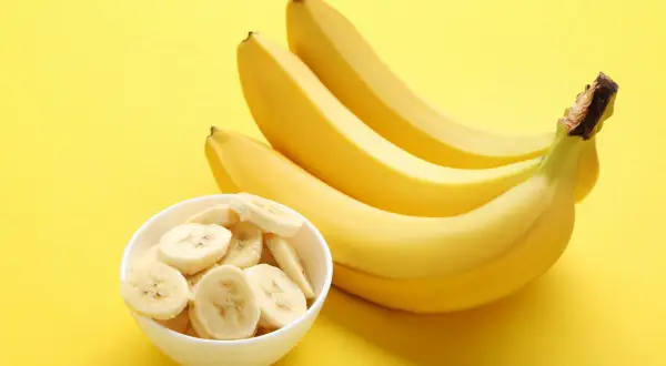 Kilka dojrzałych bananów i miseczka pokrojonych plasterków. Banan kalorie są niskie, co czyni go świetną przekąską.