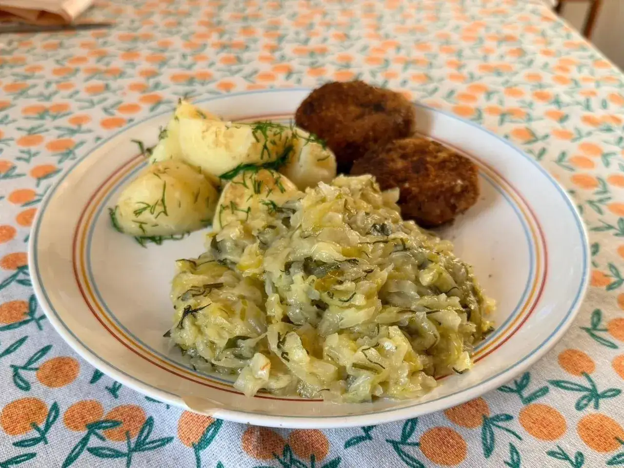 Talerz z kotletami, ziemniakami i gęstą kapustą z koperkiem. Pyszny, domowy obiad.