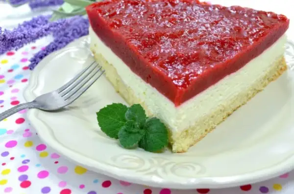 Pyszny biszkopt z serkiem mascarpone i galaretką, udekorowany miętą. Idealny deser na każdą okazję.