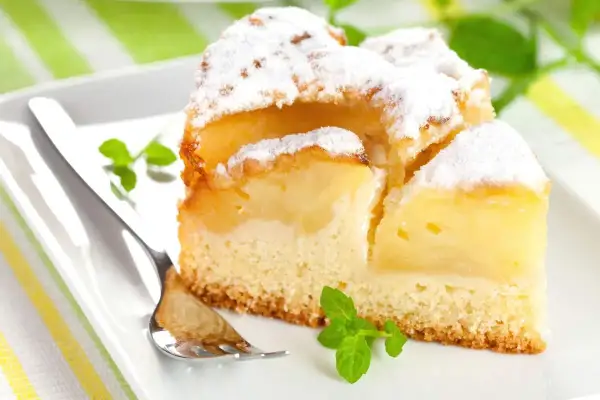 Pyszne, mega szybkie ciasto na oleju z jabłkami, posypane cukrem pudrem i udekorowane miętą. Idealne na deser.