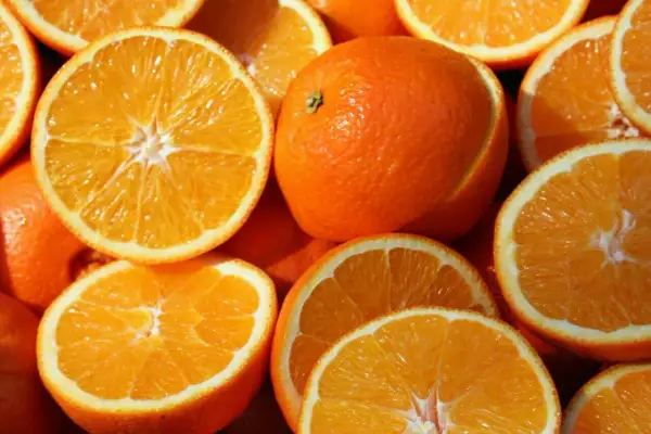 Soczyste pomarańcze, całe i przekrojone, kuszą swoim kolorem. Idealne na zdrową przekąskę, z niską zawartością pomarańcza kcal.