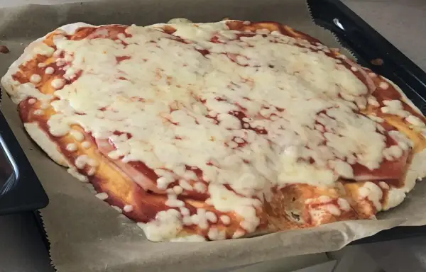 Domowa pizza z szybkim przepisem na ciasto, pokryta sosem pomidorowym i rozpływającym się serem. Idealna na szybki obiad.
